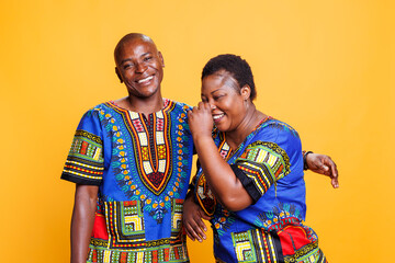 Happy romantic couple in love hugging and having fun while posing together for portrait. Woman laughing after hearing husband joke while man smiling and looking at camera
