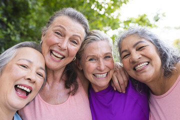 Outdoors, diverse senior female friends smiling together