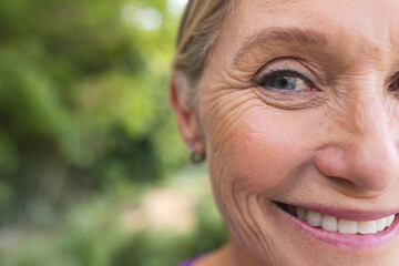 Outdoors, senior Caucasian female with smile lines showing happiness, copy space