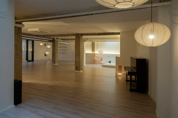 Elegant yoga studio with ambient lights, exposed beams, and a contemporary piano.