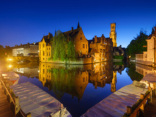 Fototapeta premium Bruges, Belgium. Historic part of the city. Architectural landscape during the blue hour. Reflections on the surface of the water. Picture for wallpaper, postcards, background, design.