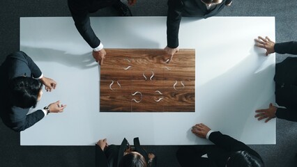 Top view of business people putting jigsaw together at meeting room. Professional marketing team...