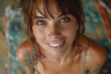 Close-up portrait of a smiling woman with sparkling green eyes and tattoos, exuding genuine warmth and spunky personality