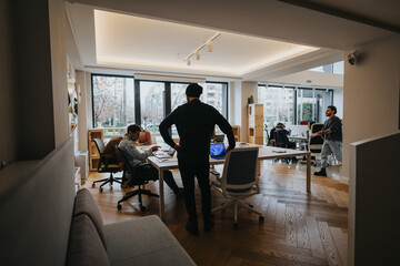Multi generational colleagues engaged in their tasks in a well-lit, contemporary office, conveying...
