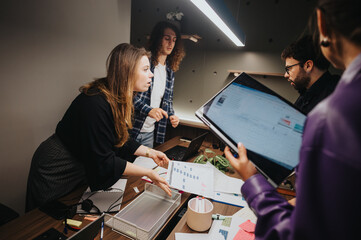 Focused business team in a heated discussion about a problematic project at a contemporary workspace. Detailed documents and digital tools in use.