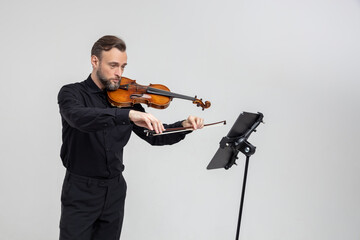 Handsome man holding a violin in his hands playing classic music