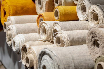 Tailor concept, Stacked cloth rolls on open air market stall, Classic pastel pattern of variety...