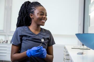 Smiling young female dentist in the office ready for dental prosthetics