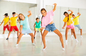 Children exercising modern dance moves together during their group classes.