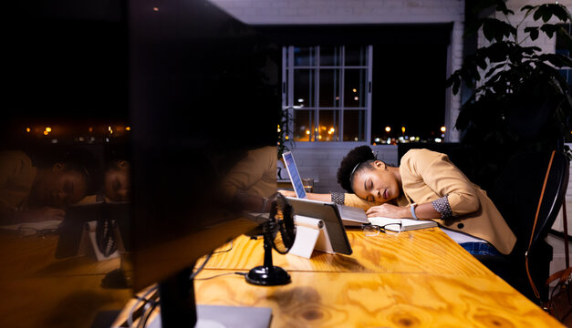 African American businesswoman rests, appearing tired at her office desk