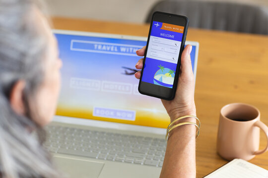 At home, Caucasian mature woman holding smartphone, booking travel