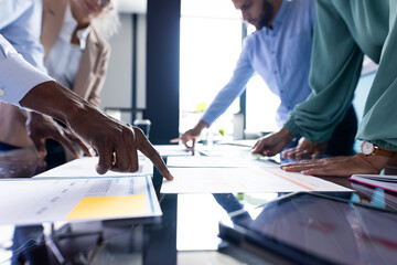 Diverse team discussing business papers at office