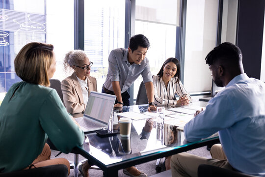 Diverse team discussing business papers at office