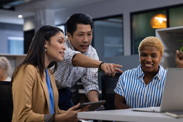 Office scene with diverse team: Asian man, African American woman, viewing screen