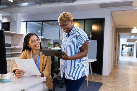 Diverse team assessing business documents together at office