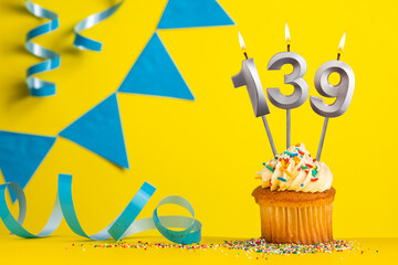 Birthday candle number 139 with cupcake - Yellow background with blue pennants