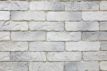A wall made of white bricks with a greyish tint