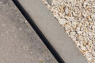 A concrete curb with a gravel border