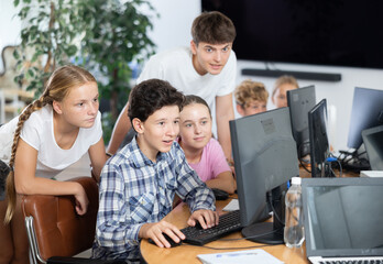 Fototapeta premium Group of children students learning to use computer in classroom