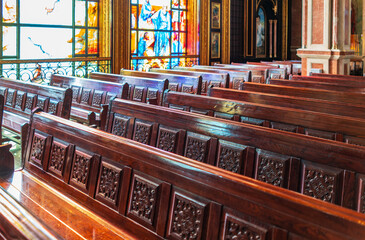 Empty wooden church benches of a Christian church. Blurry alter in the background. Selective focus....