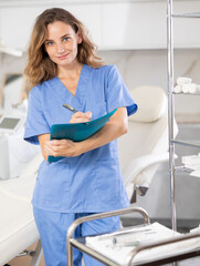 In her meticulously organized clinic, female cosmetic doctor attentively reviews patient's medical...