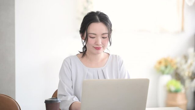 Young cute woman smiling for the camera while at the computer Front	