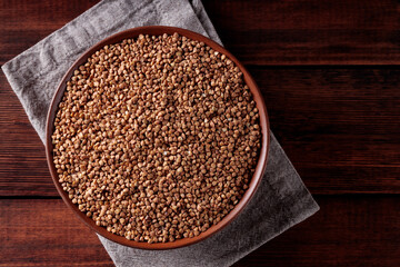 Organic Dry Buckwheat Grains on Brown Wooden Background, Copy Space