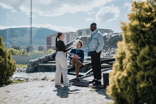 A group of business professionals, including mixed race individuals, engaging in a strategic discussion outdoors. They are analyzing data and collaborating on a project in a sunny city environment.