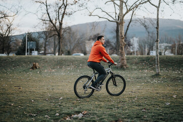A young man rides a bicycle in an urban park, enjoying the weekend with a relaxing outdoor activity, promoting fitness and well-being.