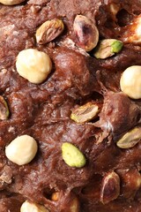 Raw chocolate dough with nuts as background, top view