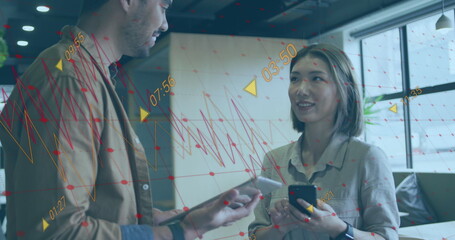 Image of multiple graphs with changing numbers over diverse coworkers discussing in office