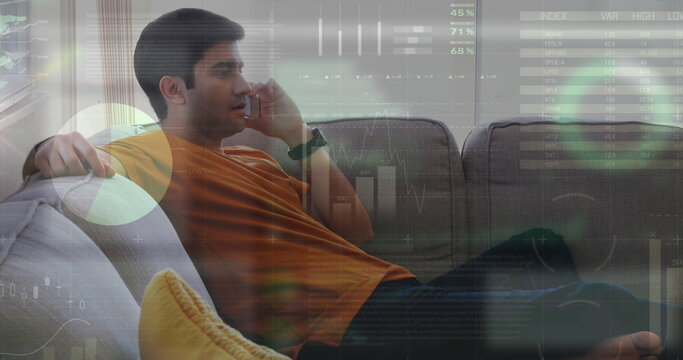 Image of infographic interface over biracial man sitting on sofa and talking on smartphone