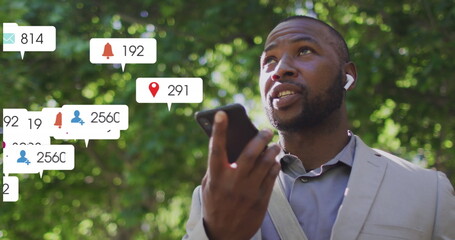 Image of notification bars over african american man talking on speaker of cellphone
