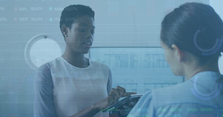 Image of statistical, stock market data processing over two diverse women discussing at office