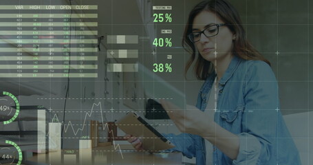 Image of statistical data processing on caucasian woman reading document using tablet at office
