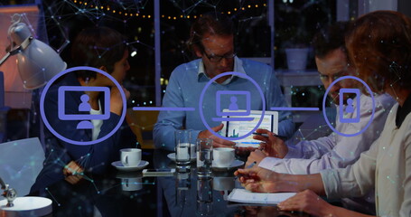 Image of network of digital icons against diverse businesspeople discussing together at office