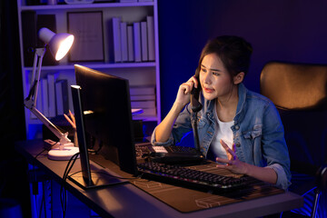 Young beautiful Asian creative woman calling on phone desk to customer or coworker explaining...