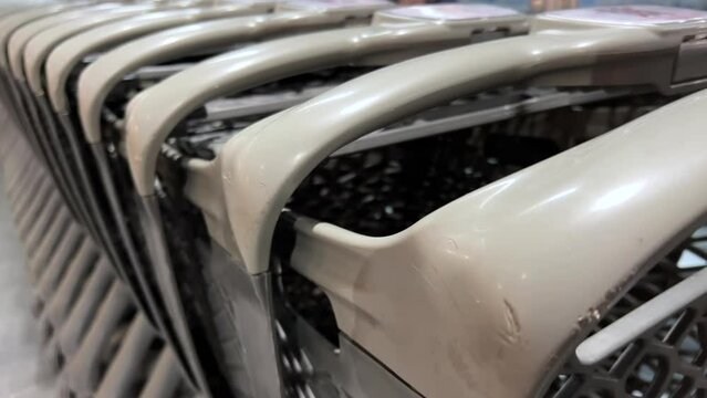 Quintessential Consumerism: An Artistic Study of Stacked Plastic Grocery Carts Awaiting Shoppers' Mundane Routines