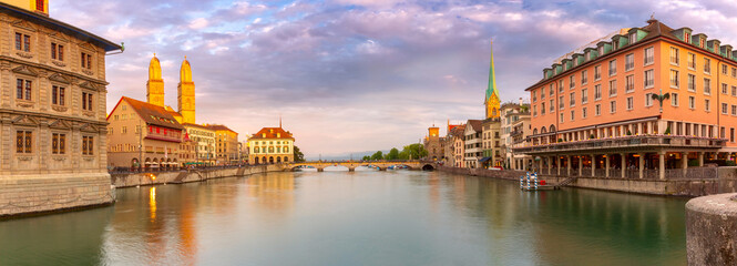 Panorama of Fraumunster church and Munsterbrucke bridge over river Limmat at sunset in Zurich,...