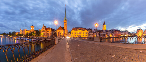 Panorama of Fraumunster church and Munsterbrucke bridge over river Limmat at sunset in Zurich,...
