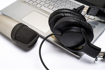 Studio microphone with studio headphones and laptop on white background