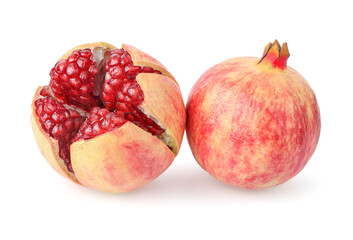 A whole pomegranate and a half pomegranate on a white background. The pomegranate on the left is...