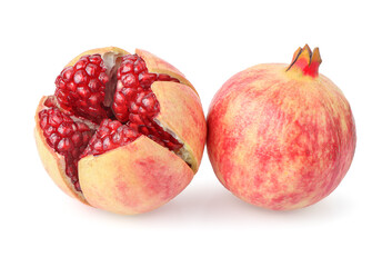 A whole pomegranate and a half pomegranate on a white background. The pomegranate on the left is whole and has a deep red color. clipping path.