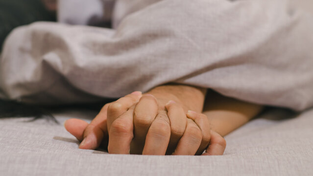 Hands of couple lovers having sex on a bed in morning with lust and love, Close up hands of a couple having sex on a bed.