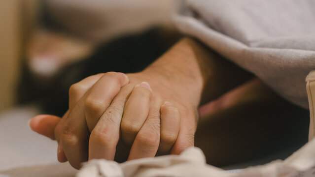 Hands of couple lovers having sex on a bed in morning with lust and love, Close up hands of a couple having sex on a bed.