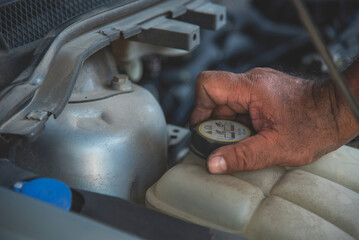 Close up Mechanic man hands repairing car auto repair shop uses jack change tyre. Man hands fixing...