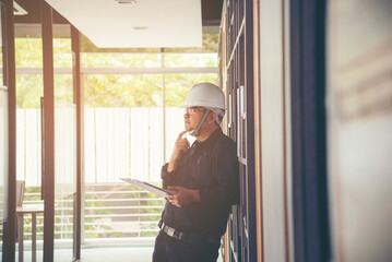 Man construction engineer writing note wear blue shirt safety white hard hat at construction site. Industry labour male worker. Architecture man drawing engineer civil constrcution real estate