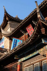 Naklejka premium A traditional Chinese opera house adorned with colorful banners, ornate carvings, and dramatic rooflines, alive with cultural performa, Generative AI