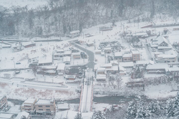 view of village with snow in winter from mountain viewpoint of Yamadera temple, the popular name for the Buddhist temple of Risshakuji located in Yamagata City, in Yamagata Prefecture, Tohuku, Japan