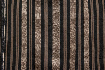 A black and brown striped fabric with a gold stripe